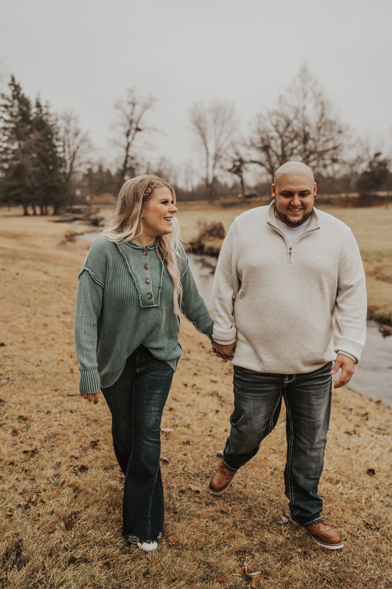 Couple walking together on a rustic trail during autumn season.