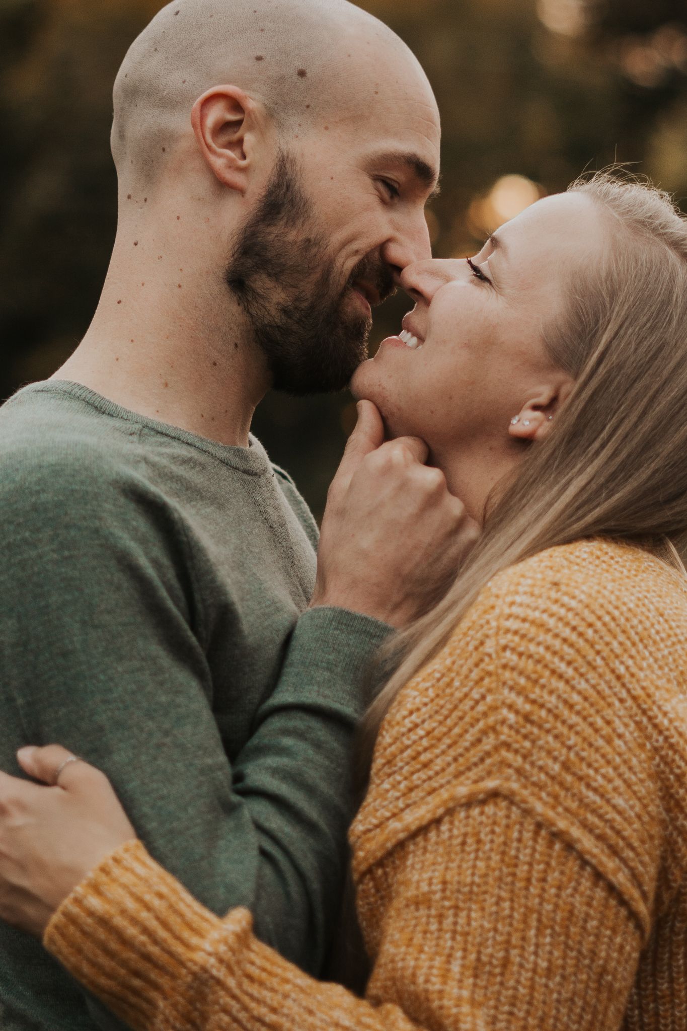 Intimate close-up of couple sharing tender moment in autumn setting.