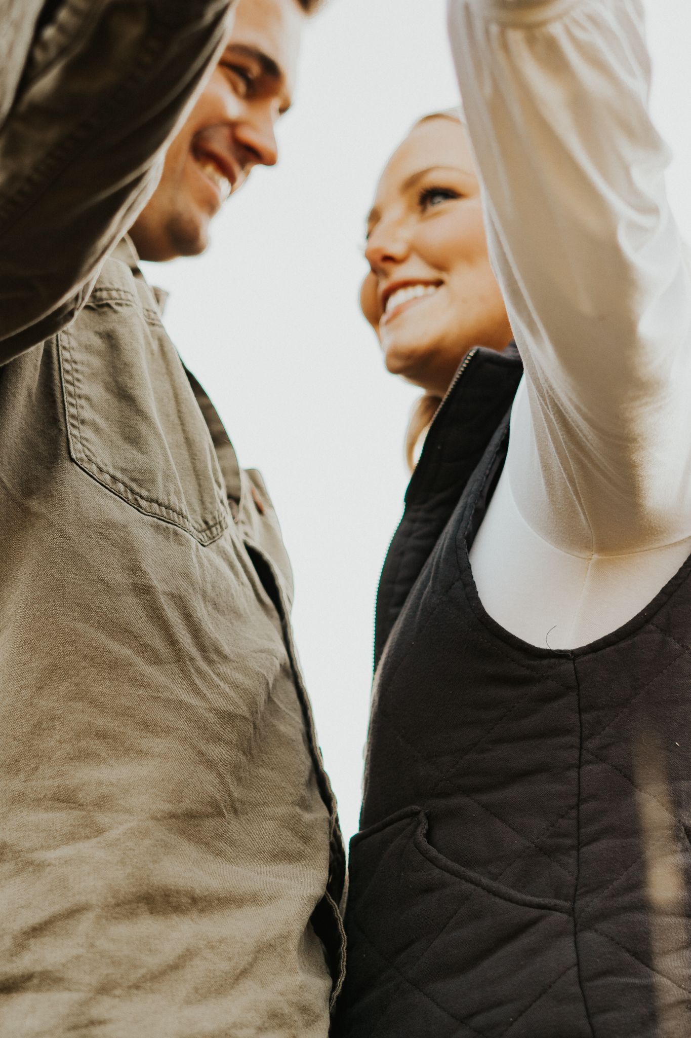Artistic close-up portrait of a couple sharing an intimate moment against white background.