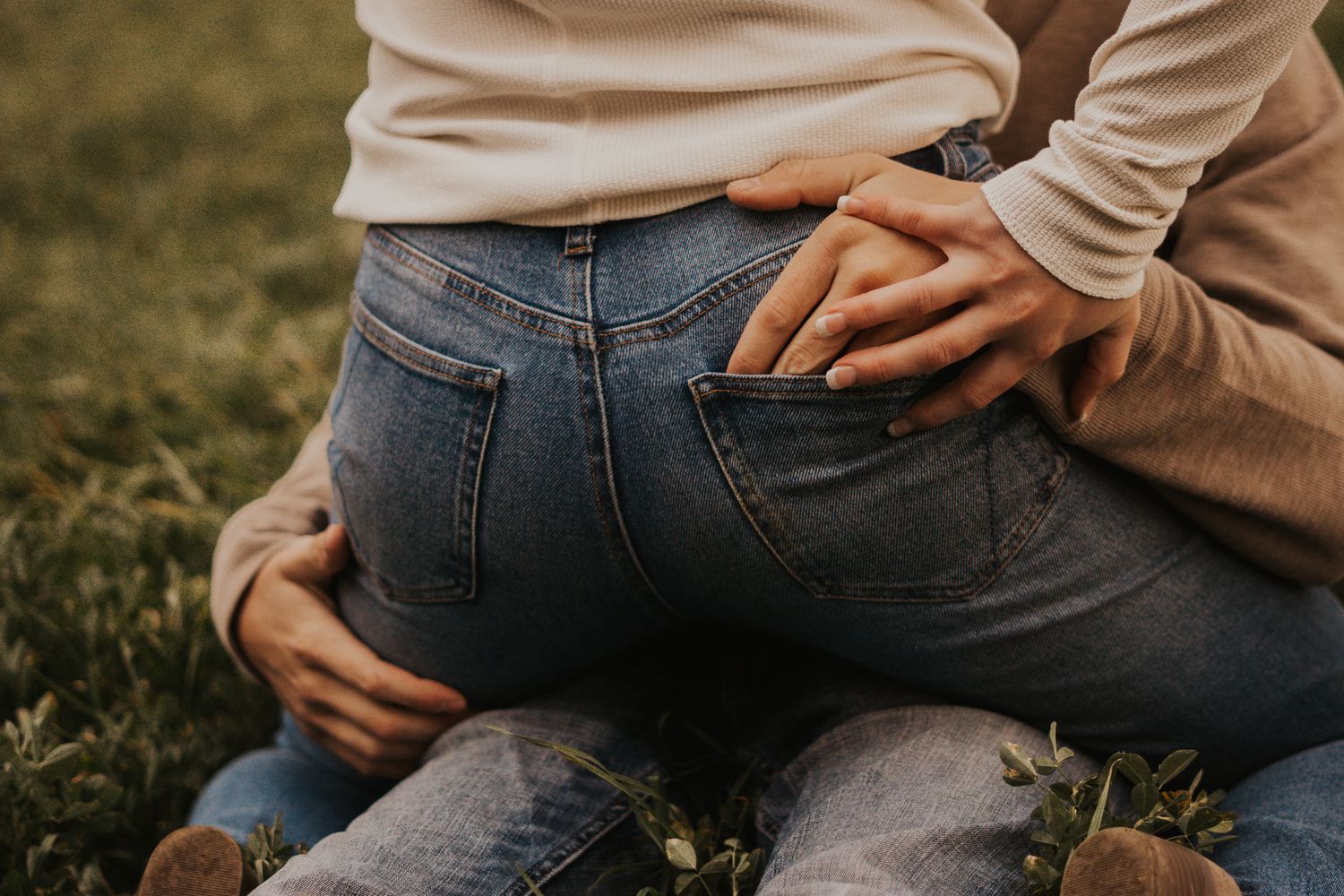 Close-up details of couple in casual denim and sweaters during autumn photoshoot.