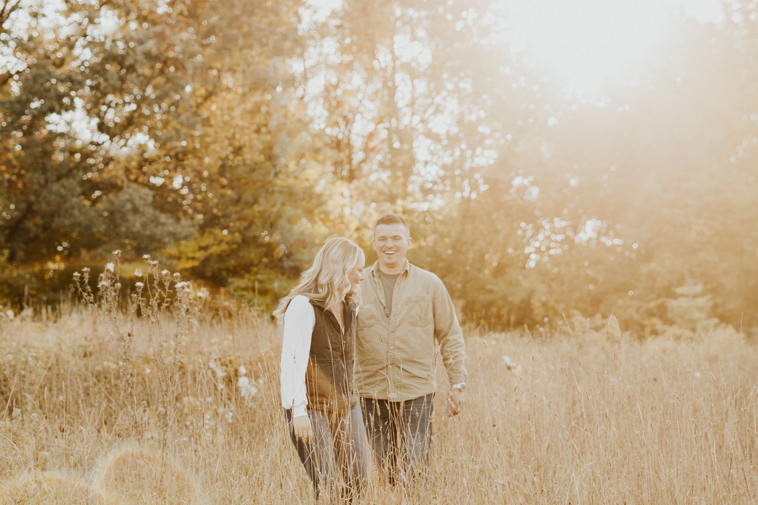 Couple enjoying tender moment in sunlit autumn field.