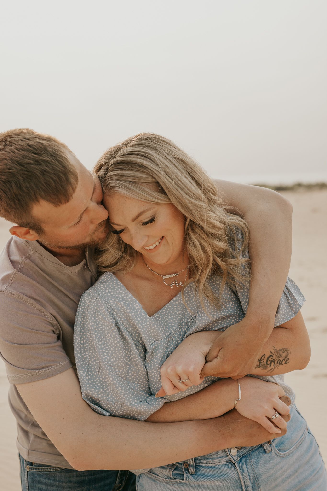 Michigan couple embracing on white background in casual attire showing tender affection.