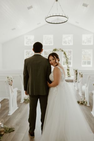 Elegant chapel interior with white floral arch and circular chandelier.