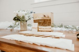 Wedding stationery and delicate floral arrangement displayed on wooden table with vintage decor.