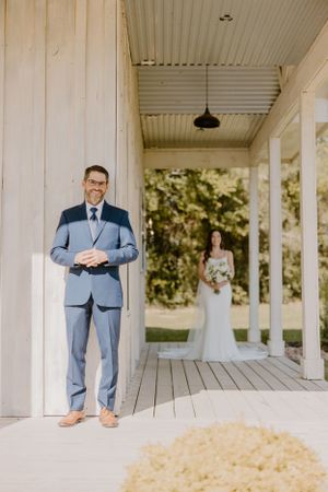 First look moment on white porch with couple standing apart.