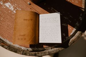 A handwritten note lies on a worn wooden surface in natural light.