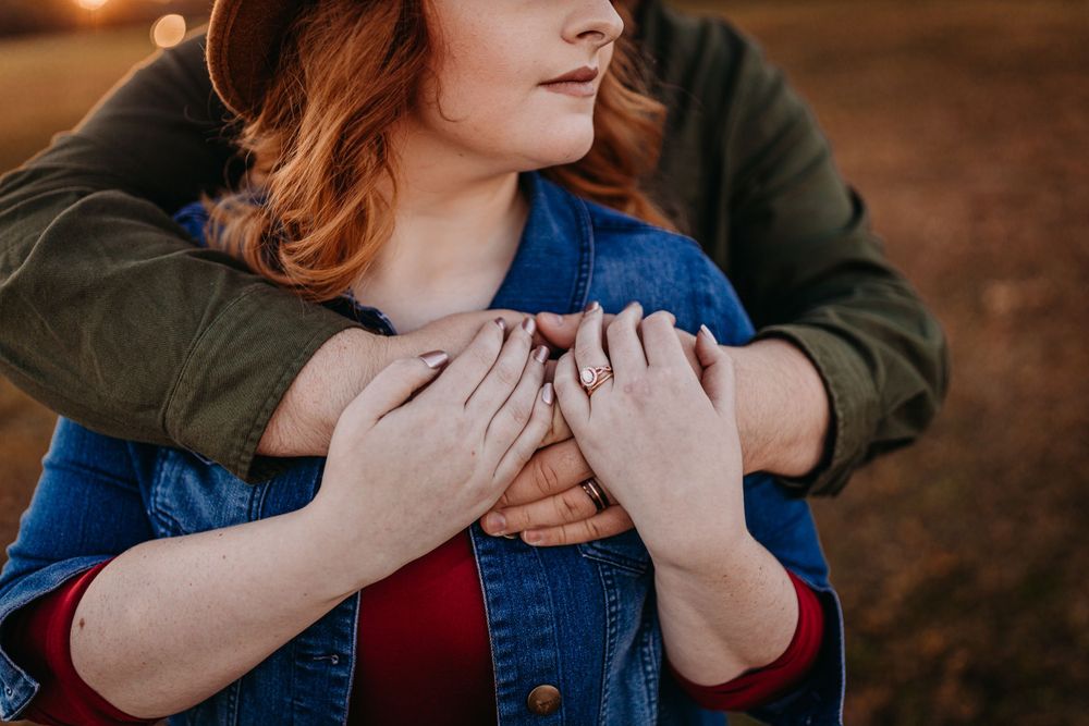 Close up of couple embracing wearing denim and olive green jacket.