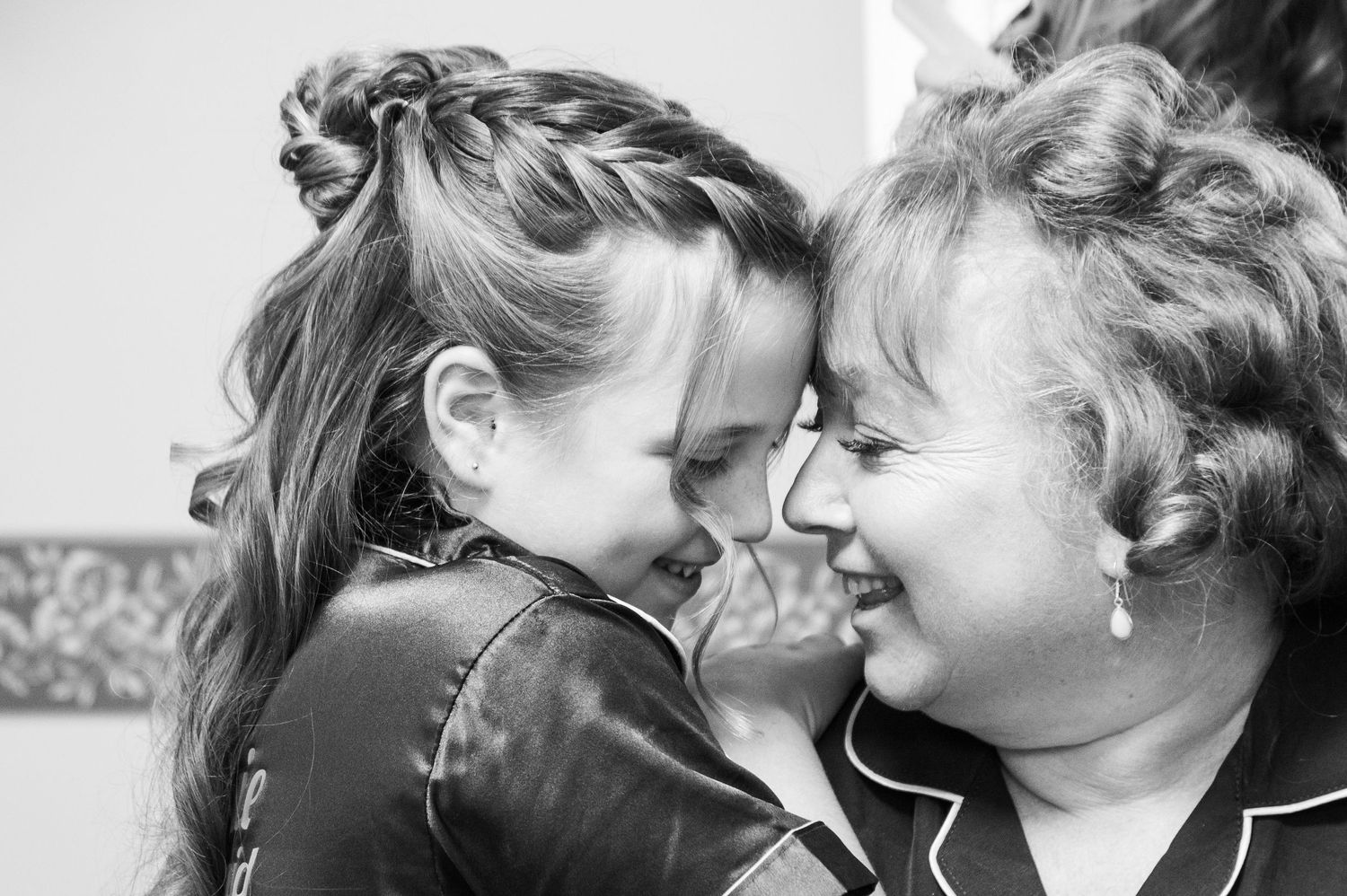 Intimate black and white portrait showing tender moment between two people.
