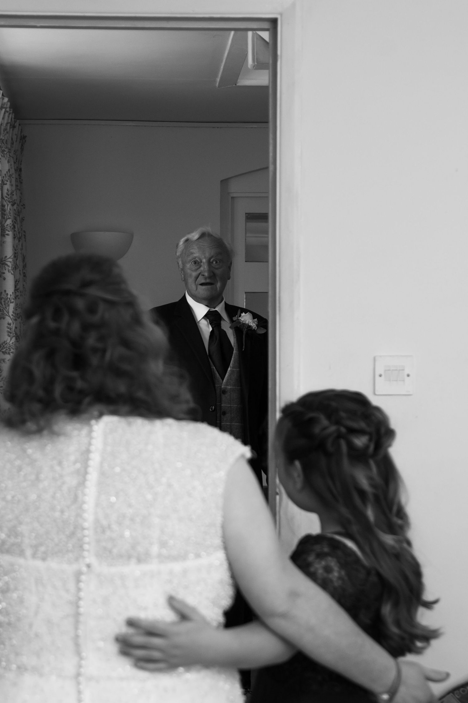 A tender first look moment captured from behind in black and white.