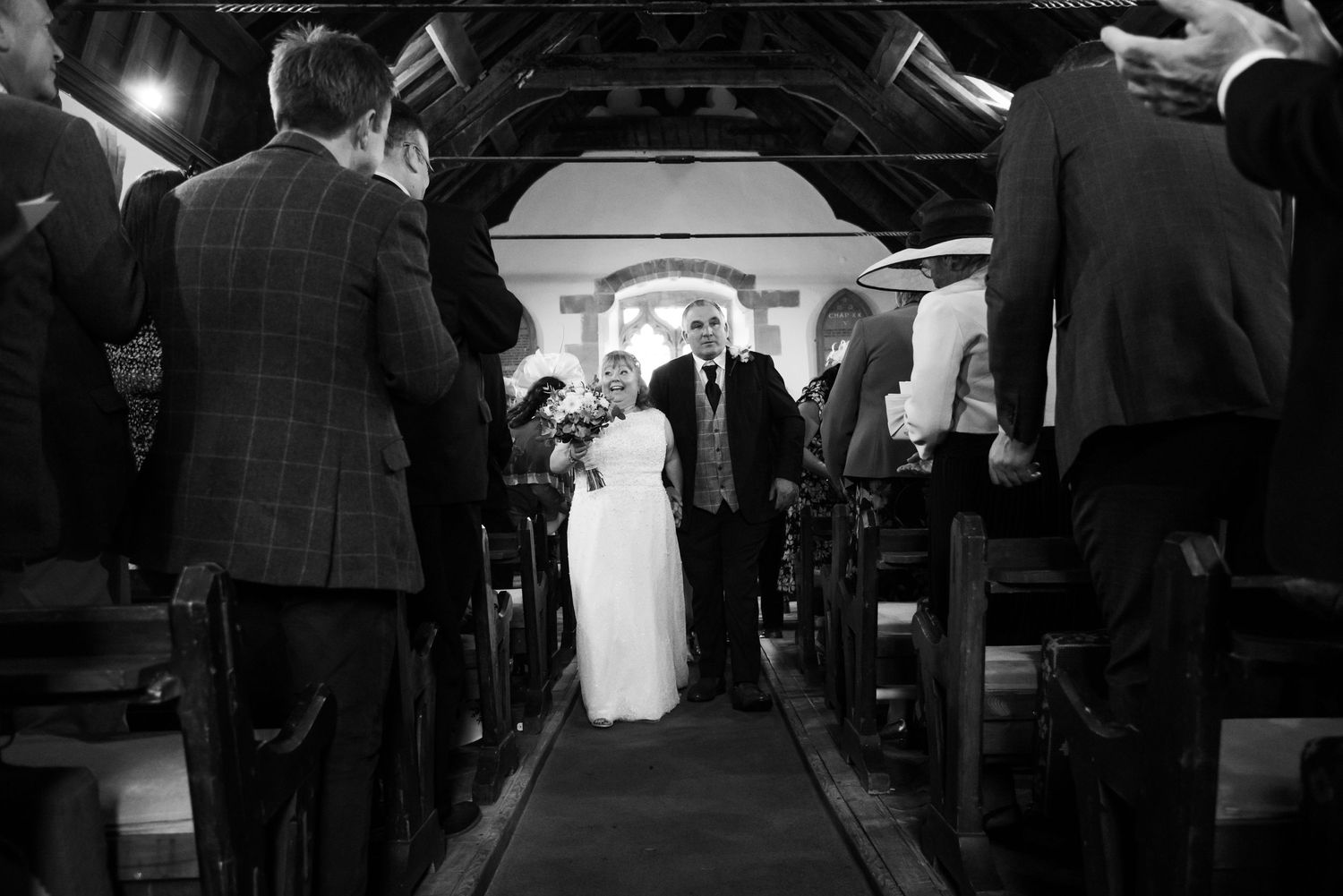 Dark silhouette of wedding ceremony attendees in a dimly lit venue.