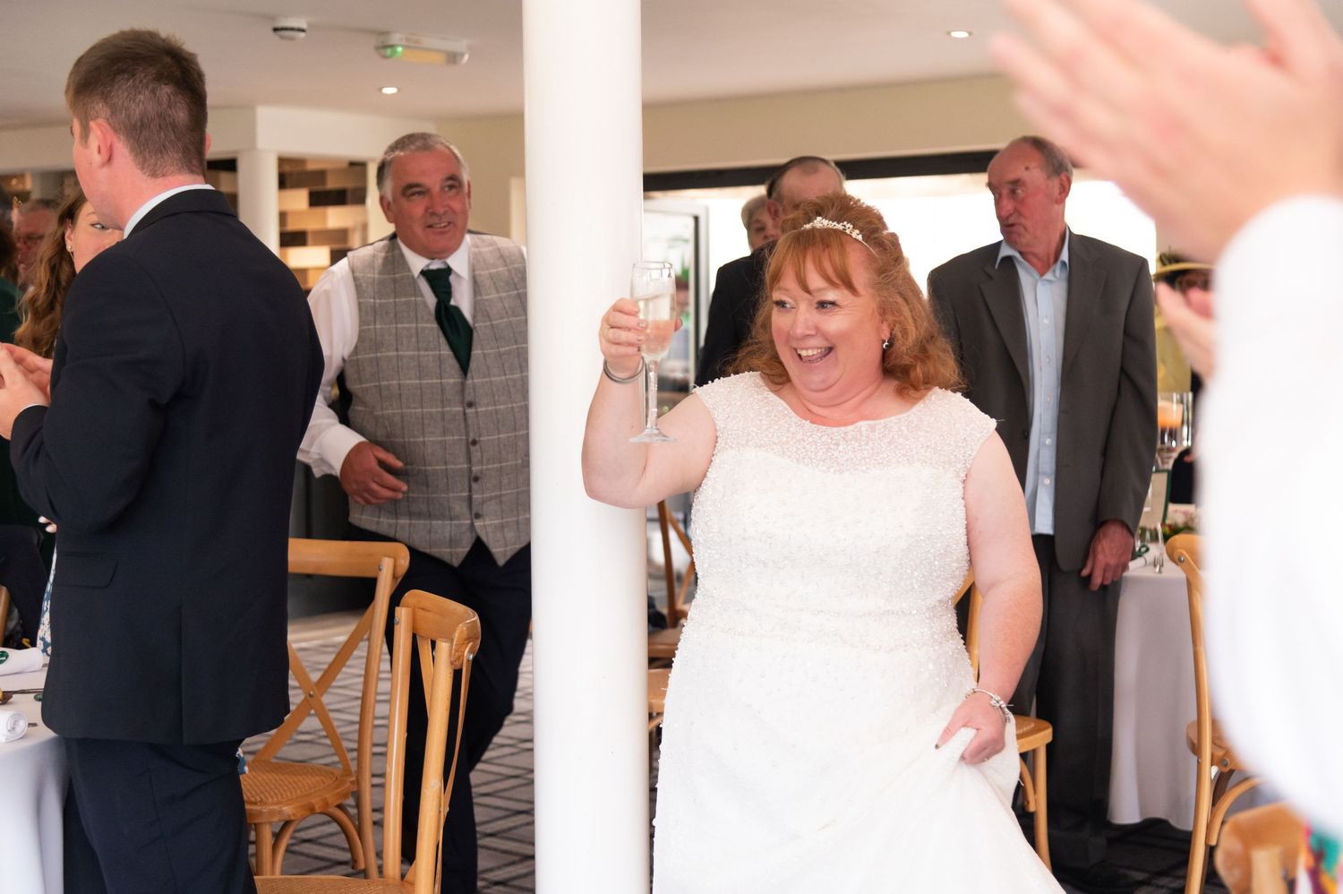 Indoor wedding reception with guests mingling in a bright venue space.