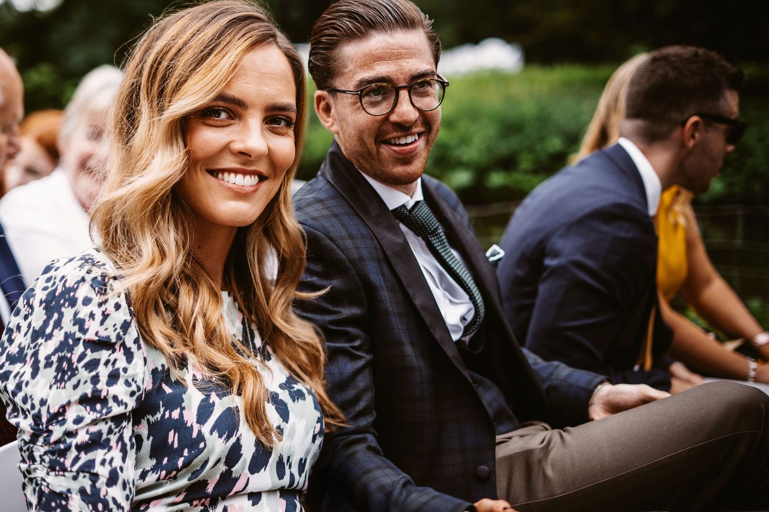 Wedding guests enjoying a social moment at an outdoor celebration.