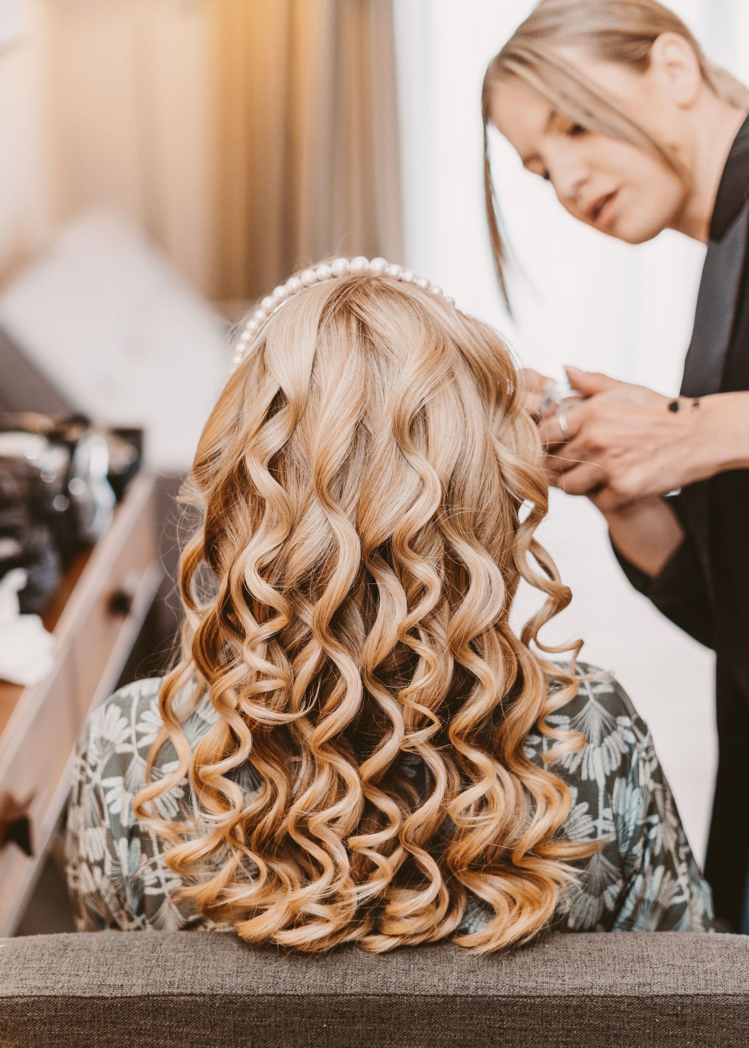 Professional hairstylist creating perfect curls for a special occasion.