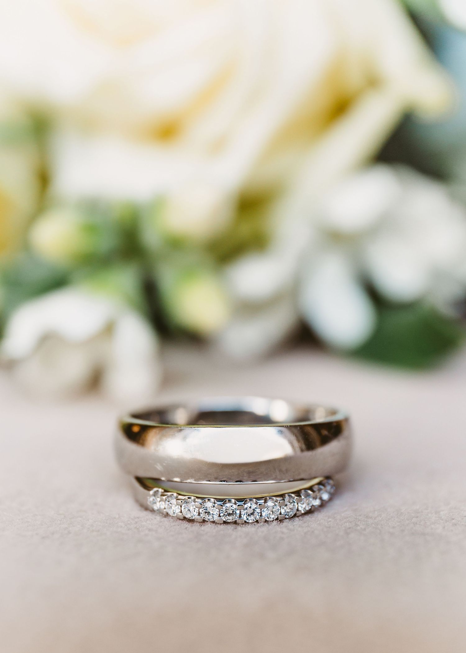 Diamond wedding ring with a modern asymmetric design on a light surface.