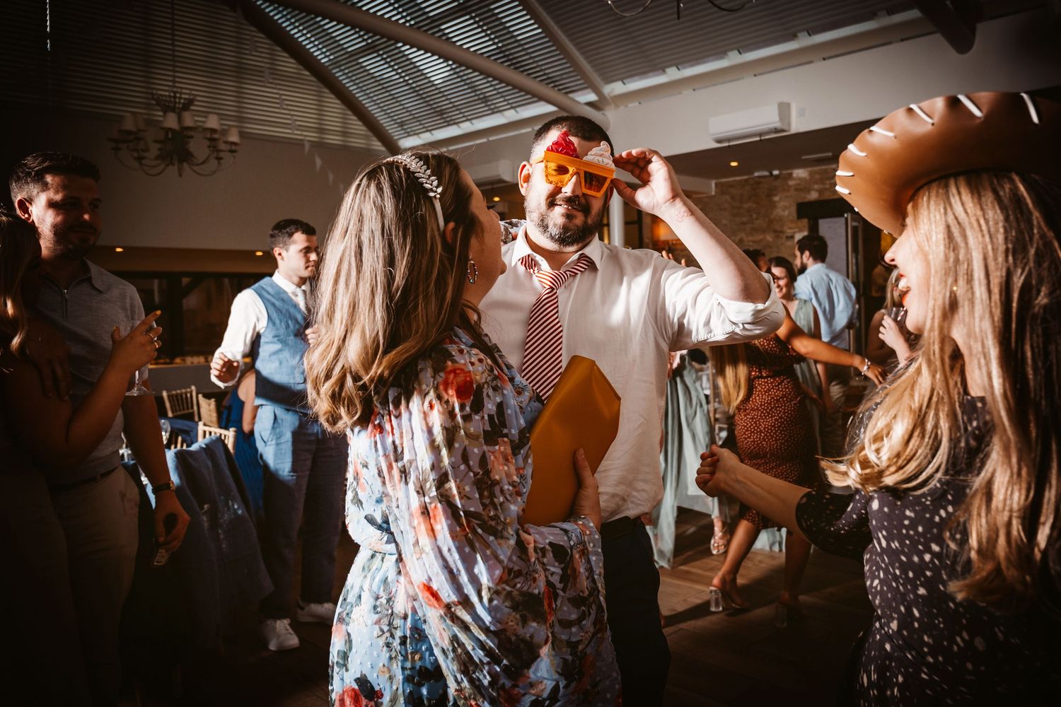 Energetic wedding reception dancing with guests enjoying themselves on the dance floor.