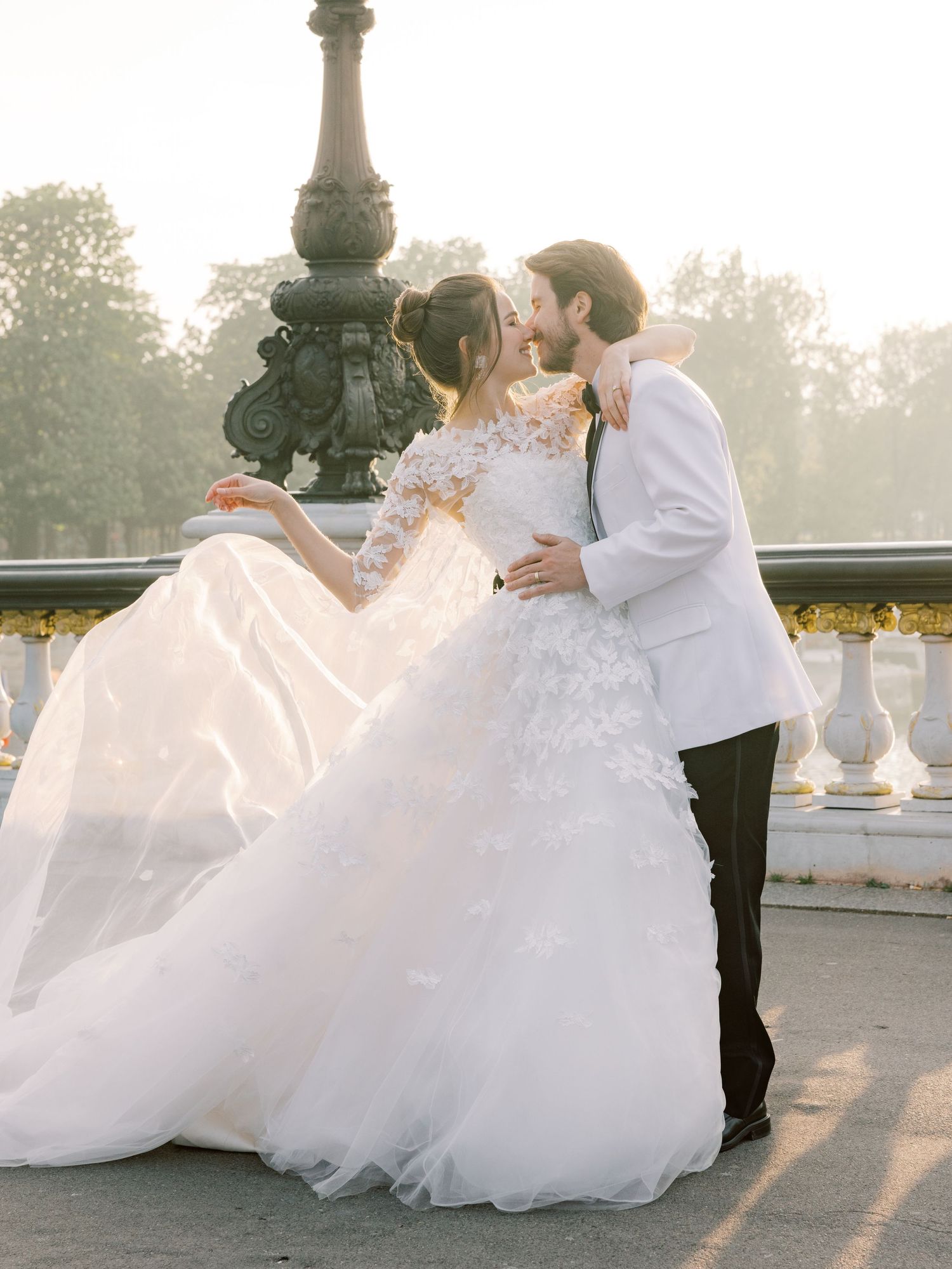 A dreamy wedding scene at sunset with flowing white dress and ornate architectural details.