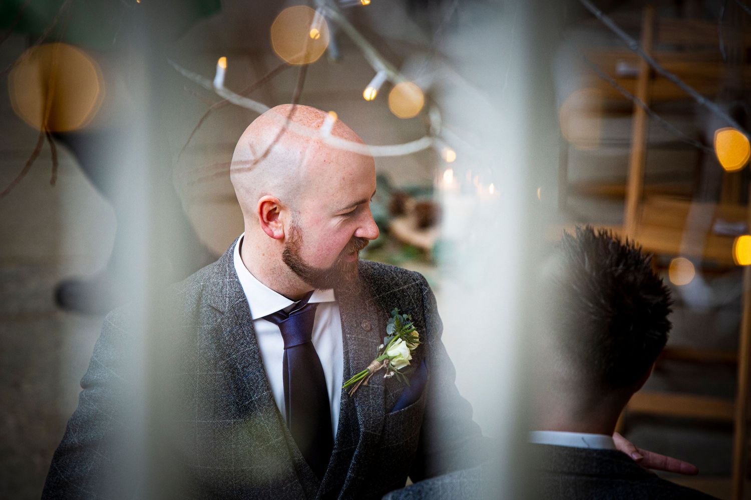 Artistic wedding photography through glass with bokeh light effects.