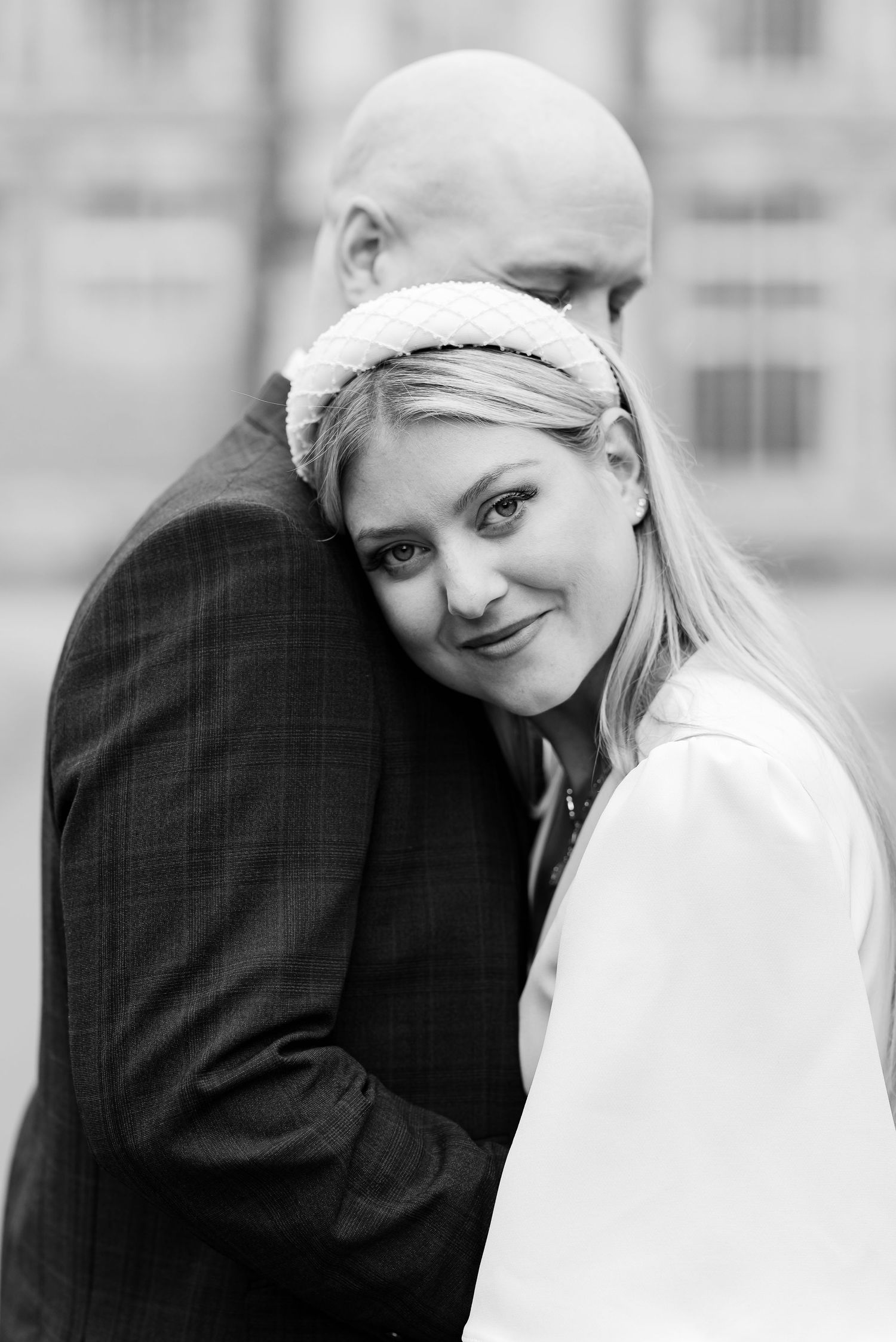 Intimate black and white portrait of newlyweds embracing outdoors.