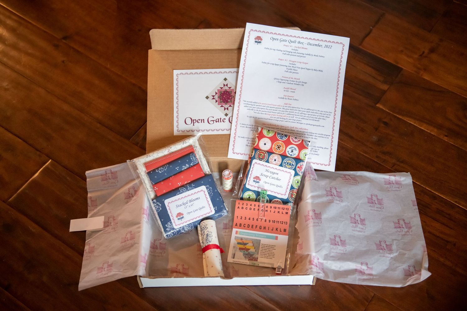 Quilt subscription box contents displayed with patterns and materials.