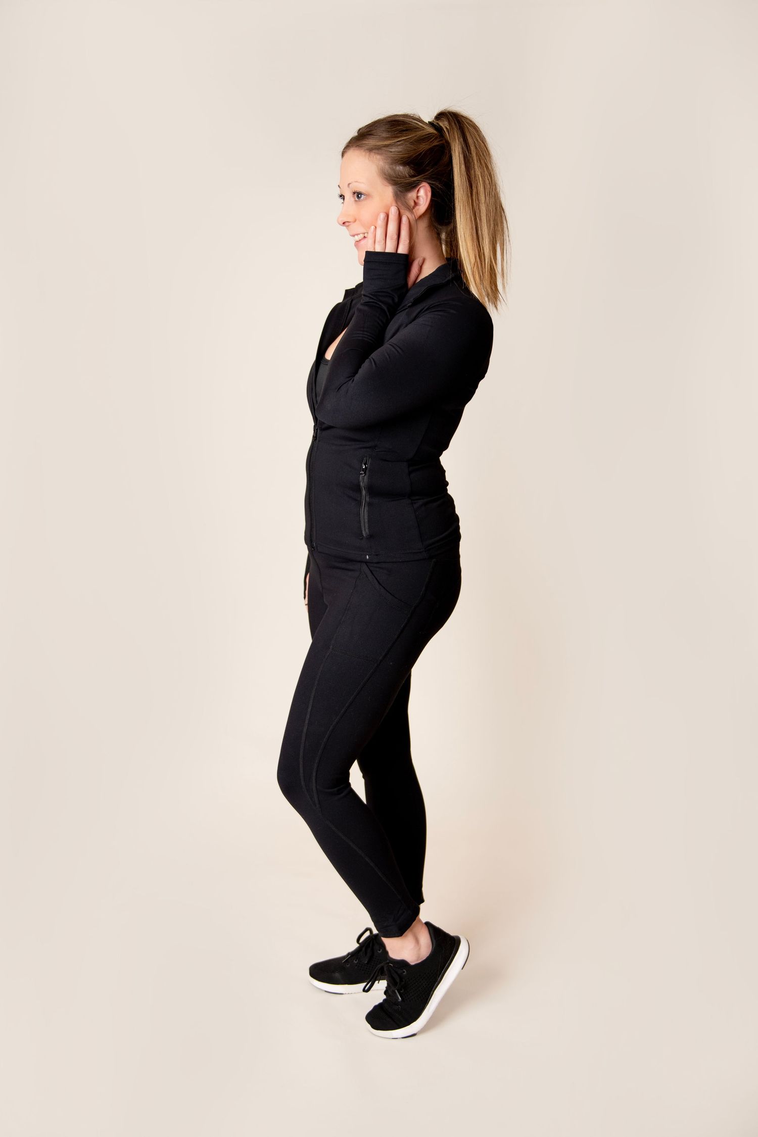 Athletic wear showcase featuring all-black attire against a white studio background.