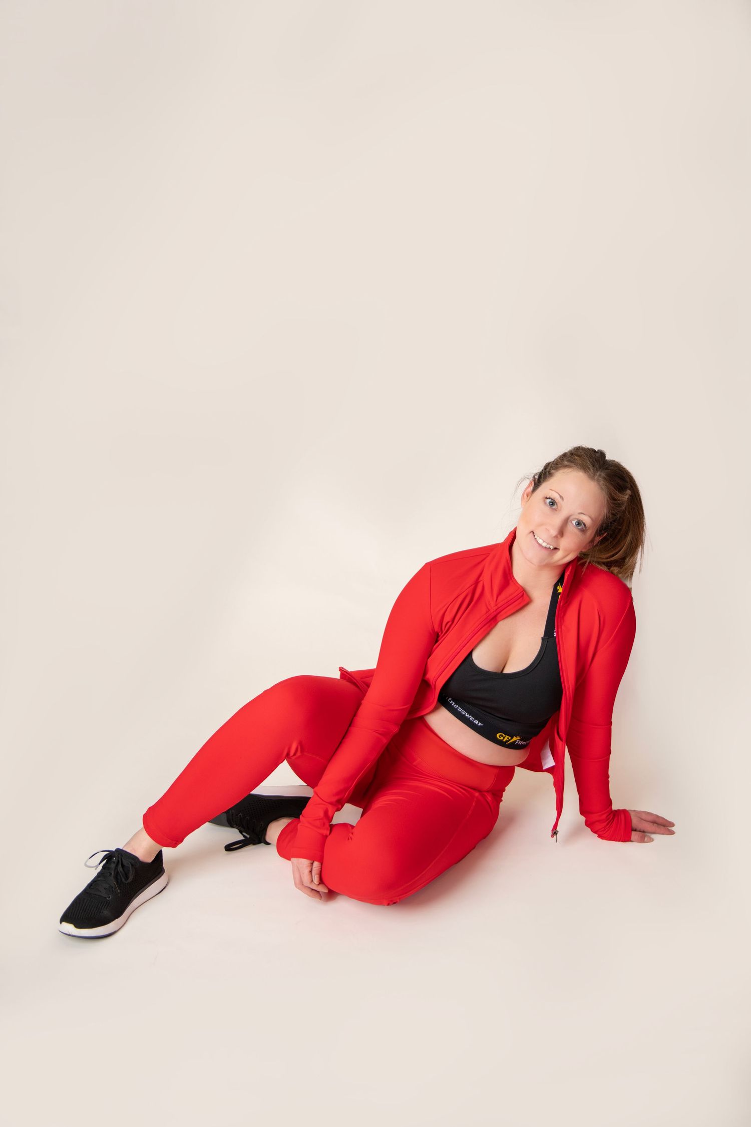 Red athletic outfit with black sports bra displayed against white studio background.