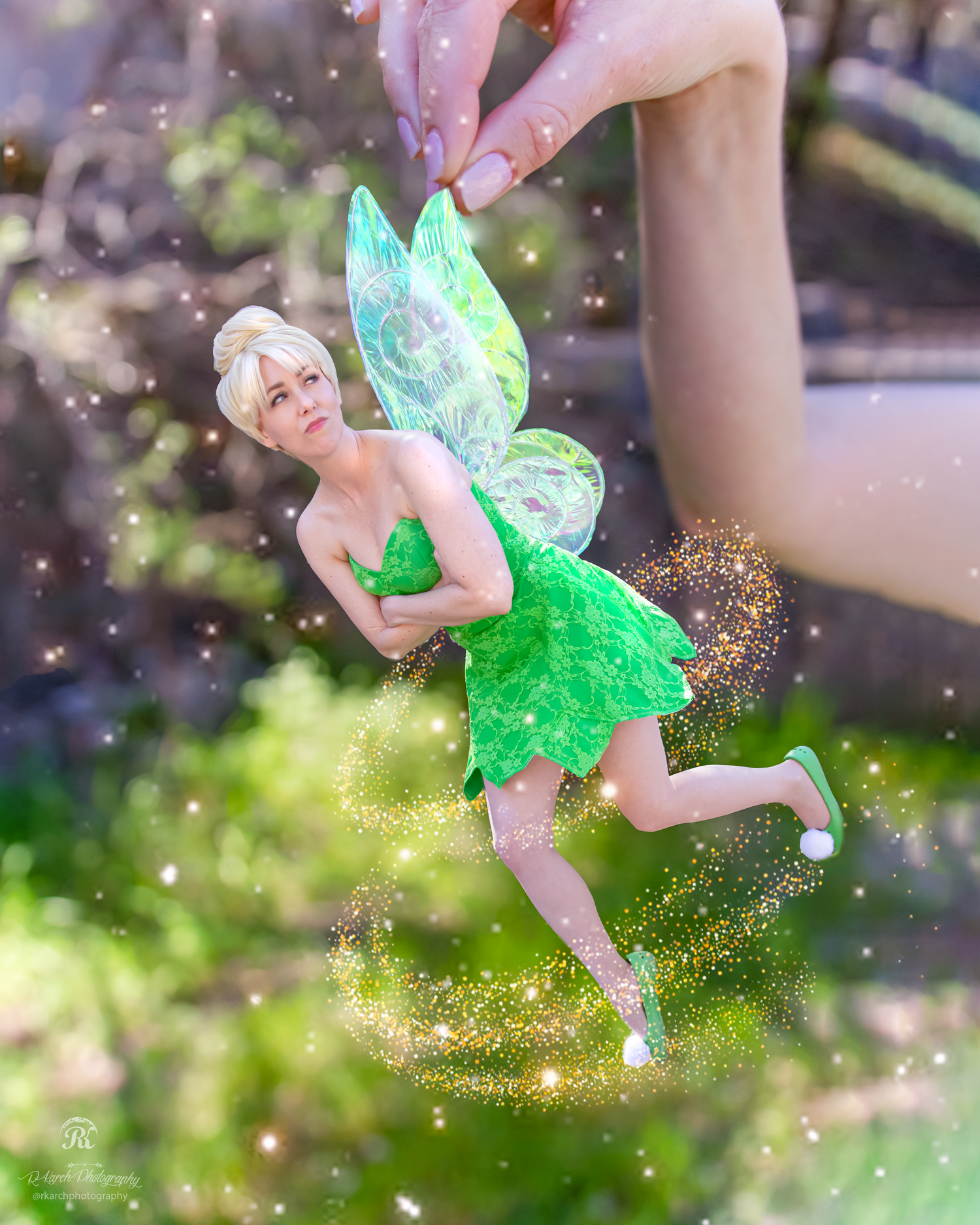 Whimsical fairy cosplay with glowing wings and sparkles in garden setting.