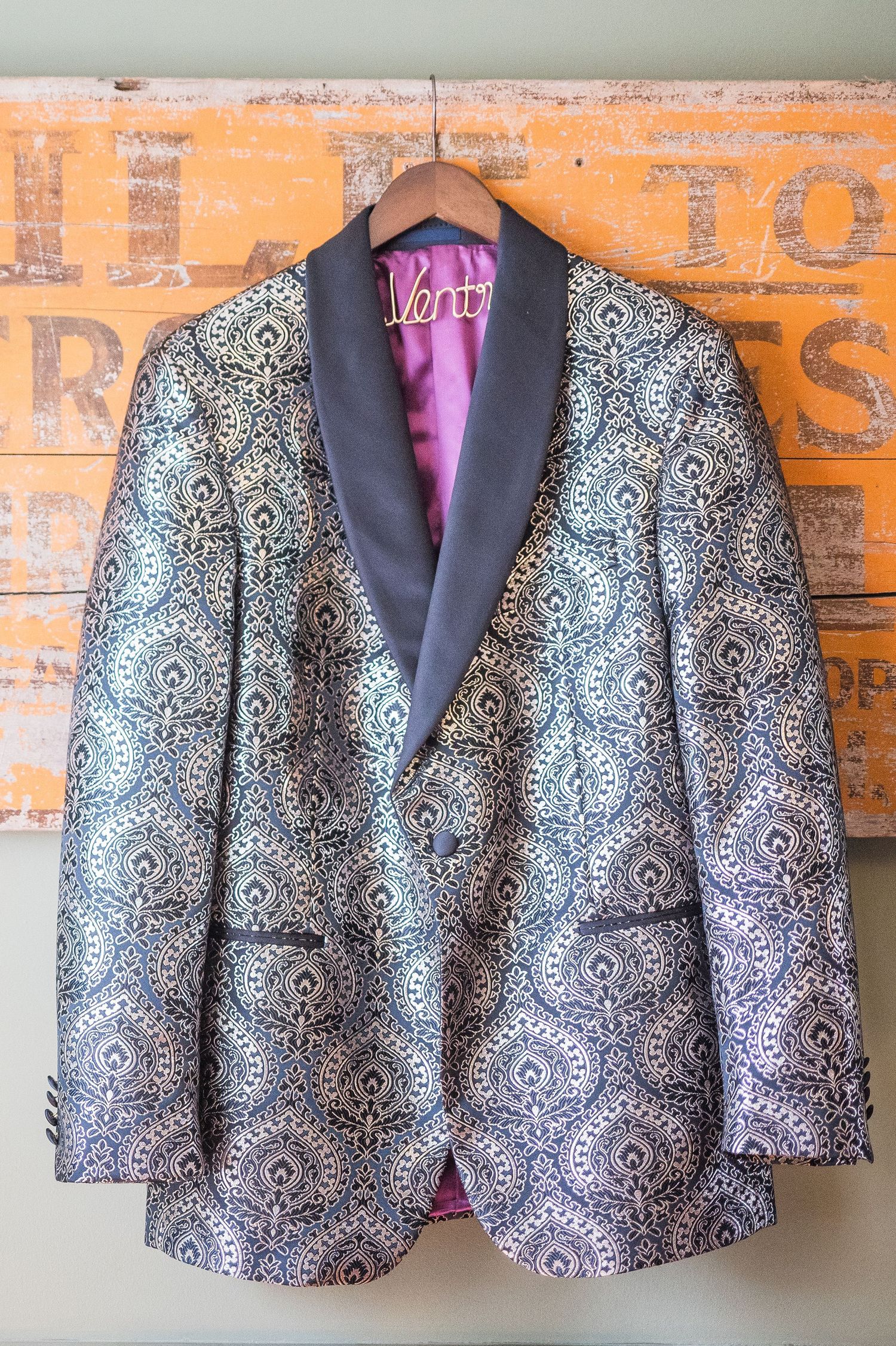 Extravagant groom's jacket hanging on a sign.