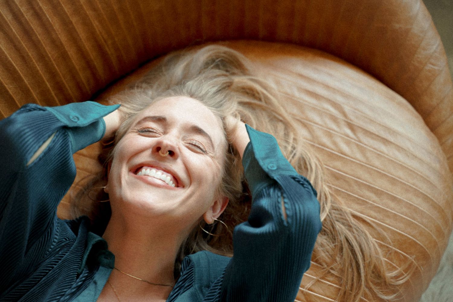 Joyful expression captured from above while lying on wooden floor.