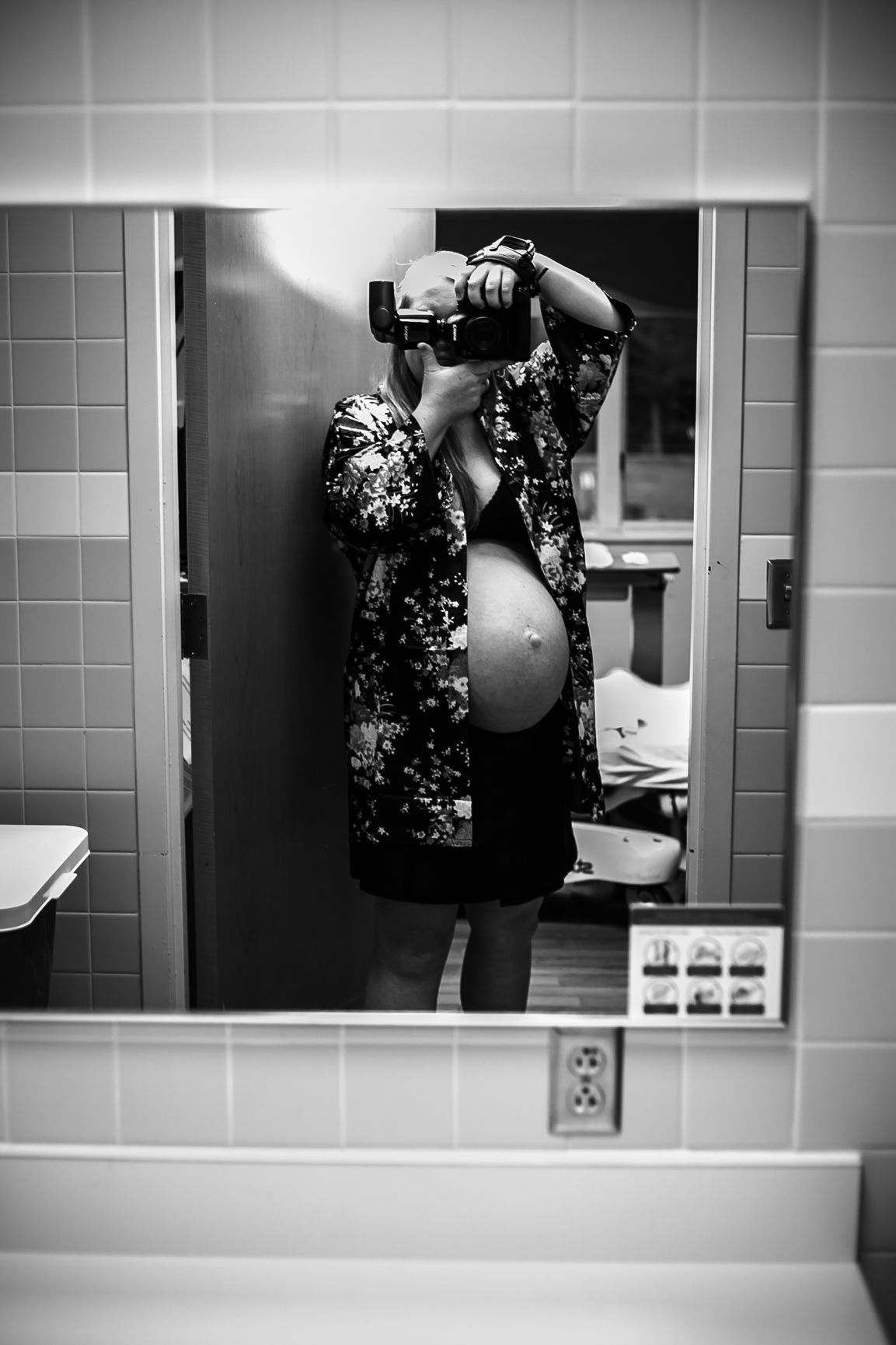 Photographer Michelle taking a photo of herself in the mirror at UnityPoint Health in Sioux City, IA, while in labor.