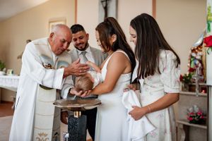 A religious baptism ceremony taking place at a church altar.