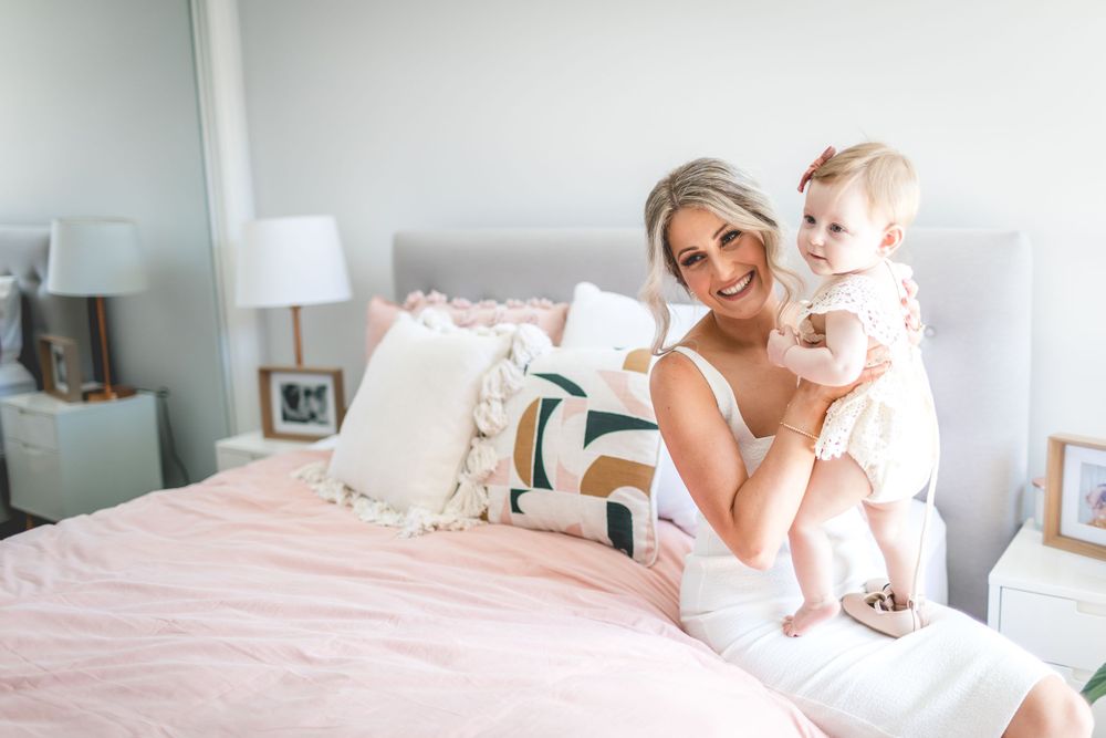 Bright and airy bedroom scene with white bedding and soft pink accents.