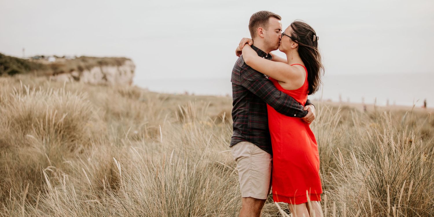 couple arms around each other Norfolk coast in sand dunes