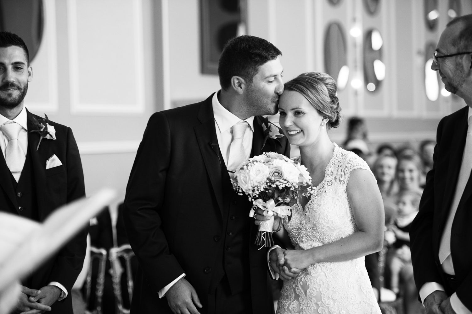 A tender black and white moment captured during an intimate wedding ceremony.