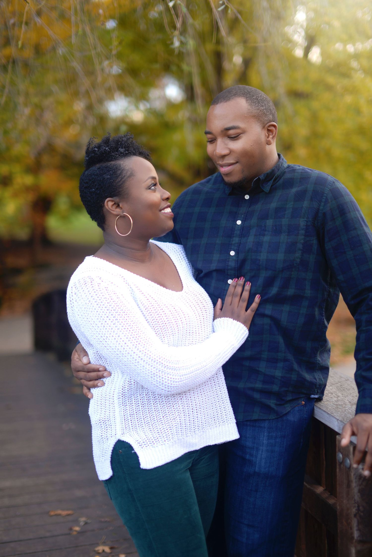 man with arm around woman looking at woman with hand on his chest looking at him