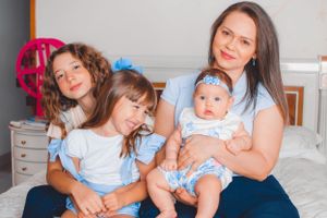 Family portrait showing warm expressions while seated together on furniture.