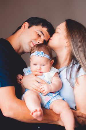 Candid family photo session capturing loving moments with baby in blue outfit.
