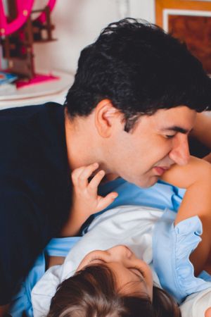 Tender parental moment with baby in light blue clothing.