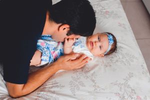 Intimate black and white family portrait capturing tender moments on white background.