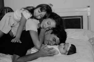 High contrast black and white family photo showing gentle embraces.