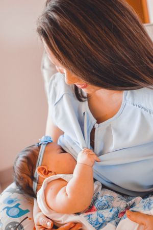 Close-up of nurturing moment between mother and baby in soft blue tones.