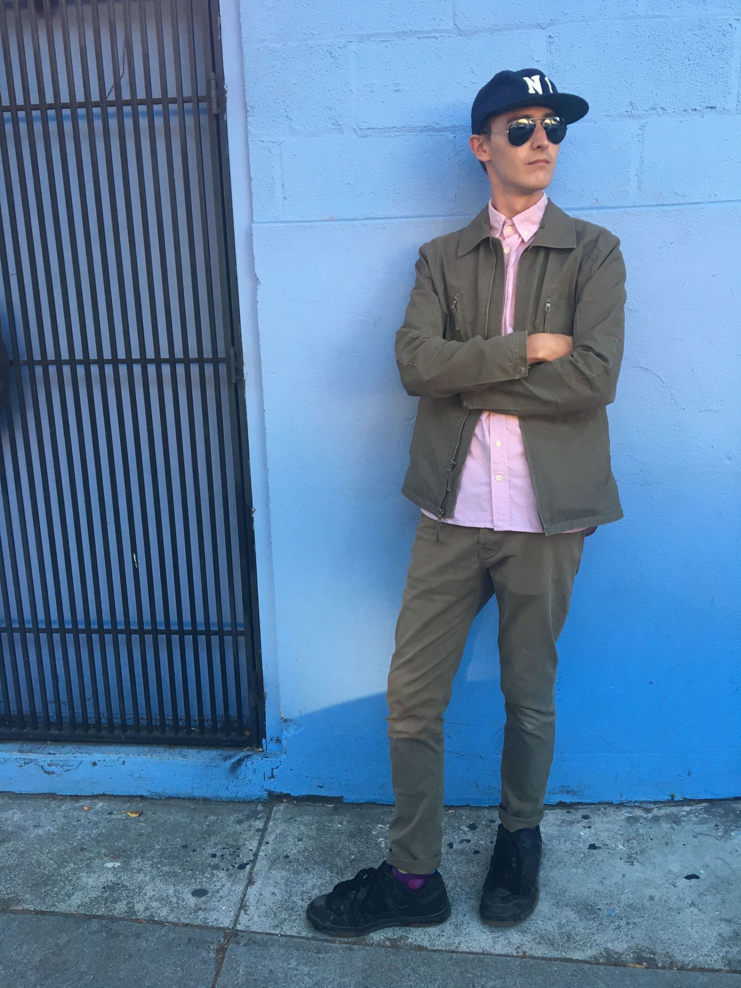 Series of photos showing someone posing against a bright blue wall wearing sunglasses and suit.