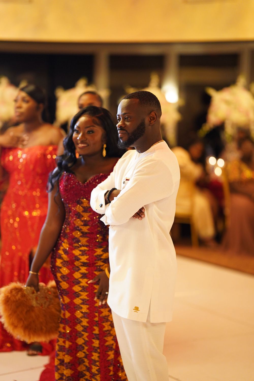 Formal celebration featuring traditional African attire and elegant white suits.