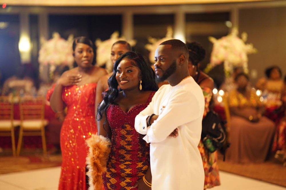 A couple dancing at a formal event with warm lighting in a ballroom setting.