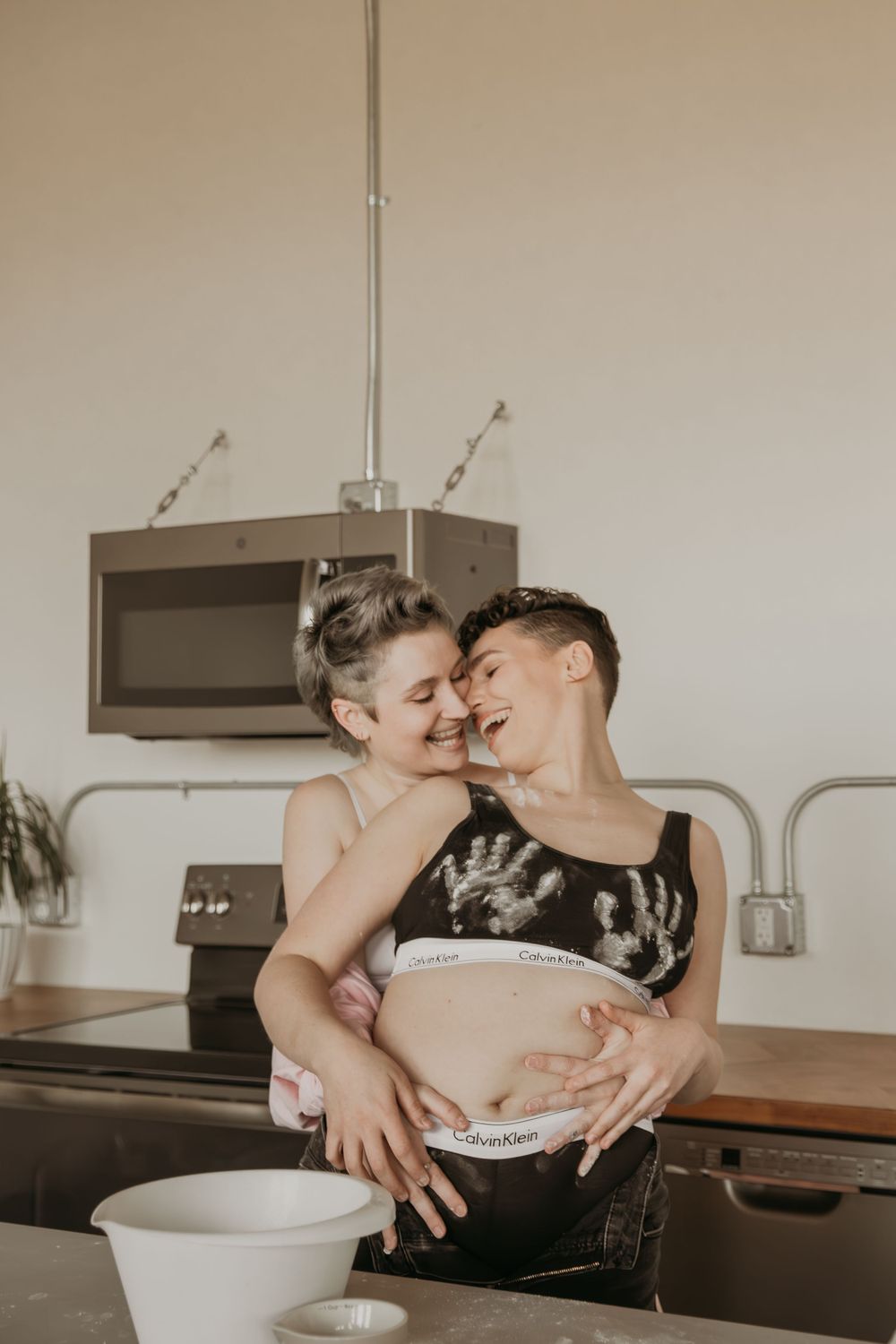 Intimate couple sharing an affectionate moment while baking together in a modern kitchen.