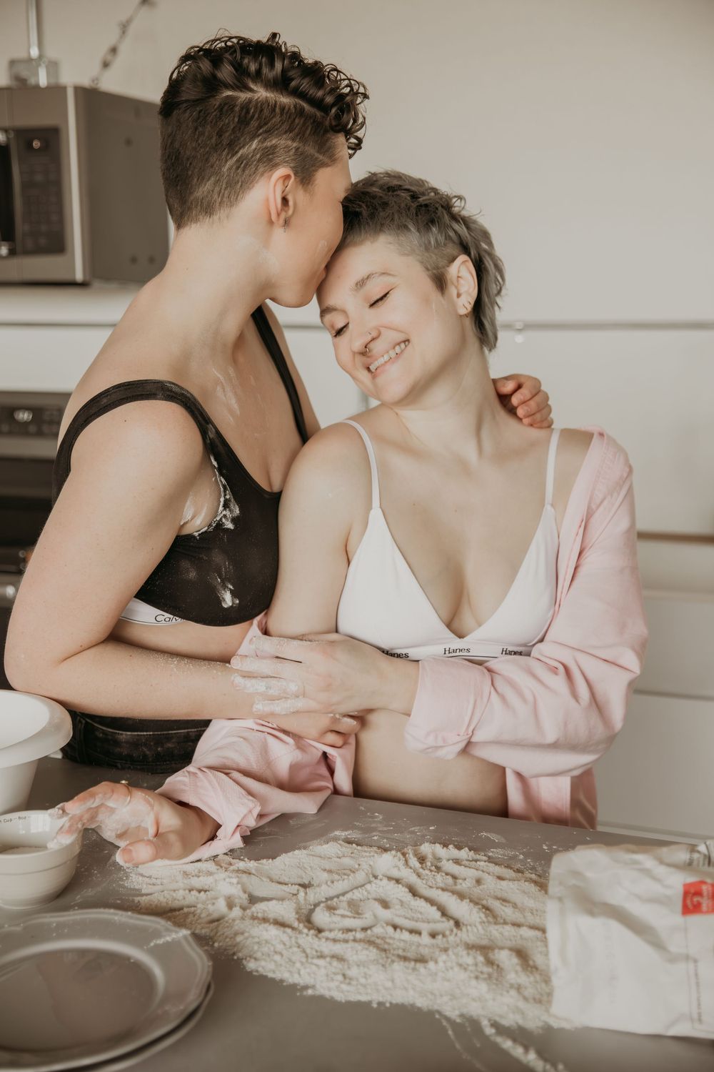 Sweet domestic moment of couple baking together in bright modern kitchen.