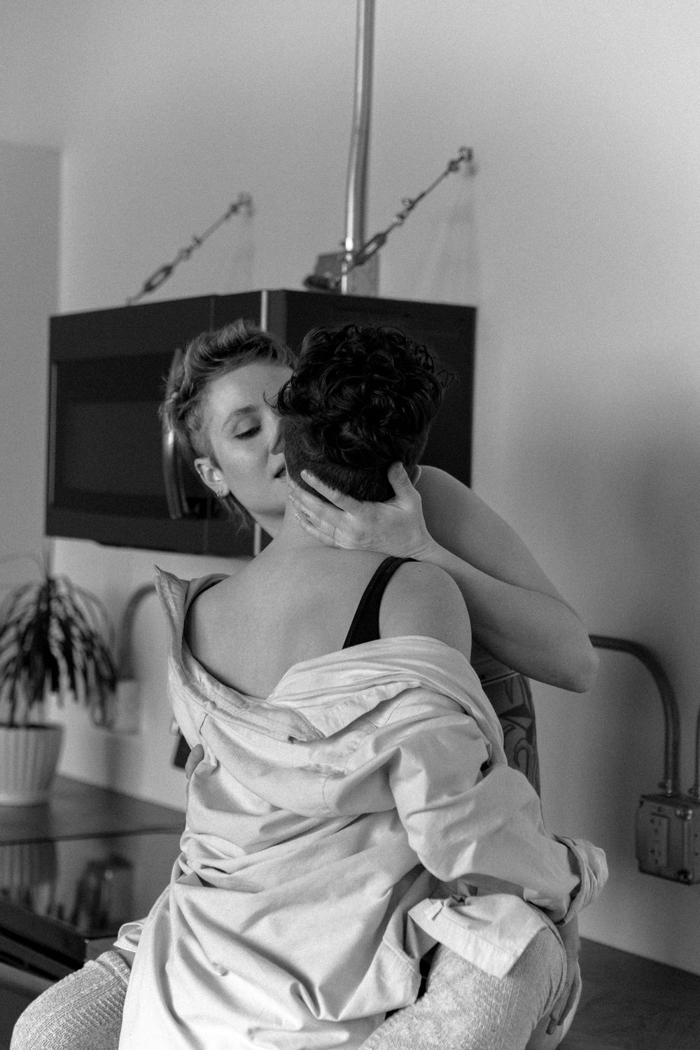 Intimate black and white kitchen scene showing tender embrace.