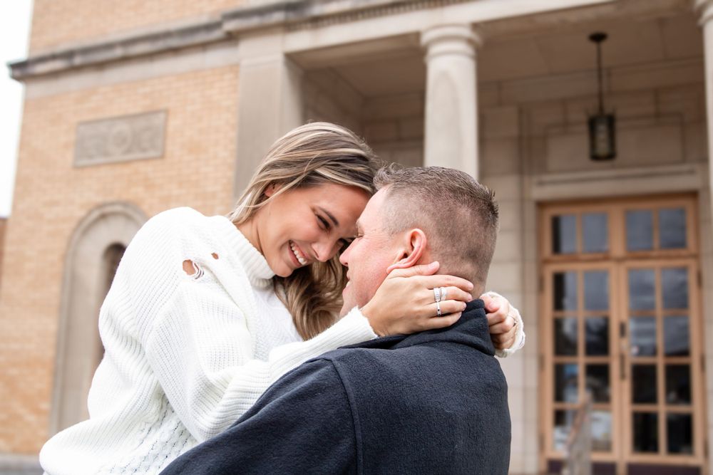 A happy couple in love, hugging in downtown,  captured by Box of Sunshine Studios