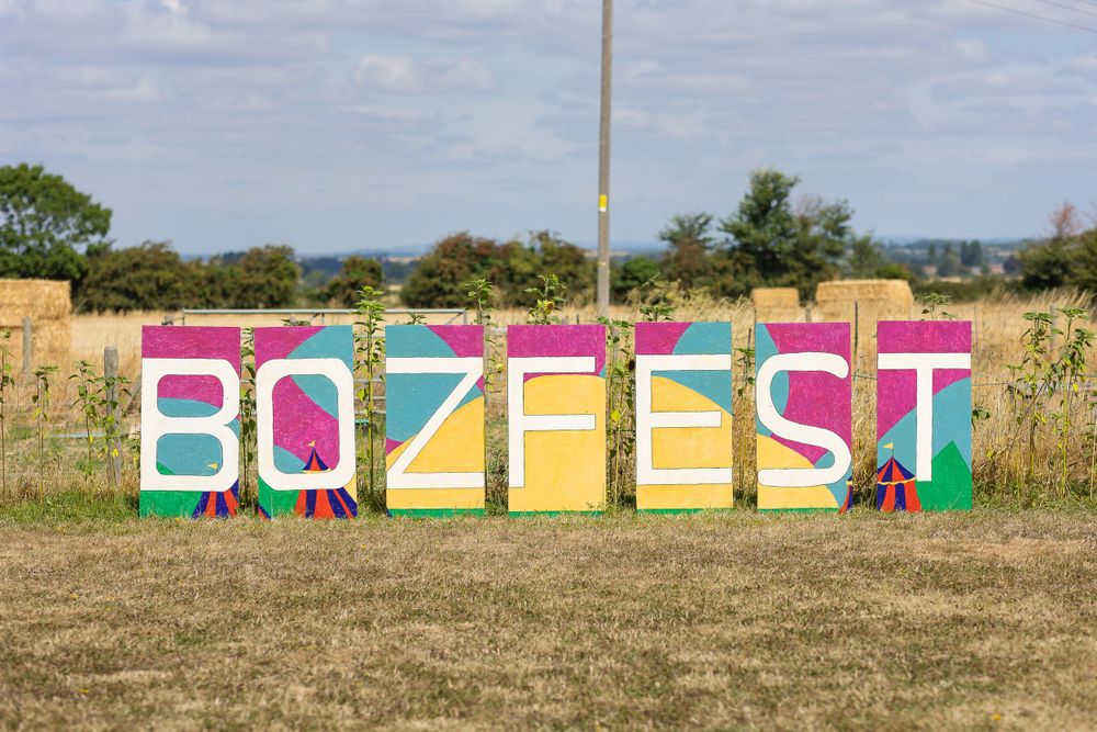 A mulit-coloured sign spells out the word Bozfest at a music festival themed wedding.
