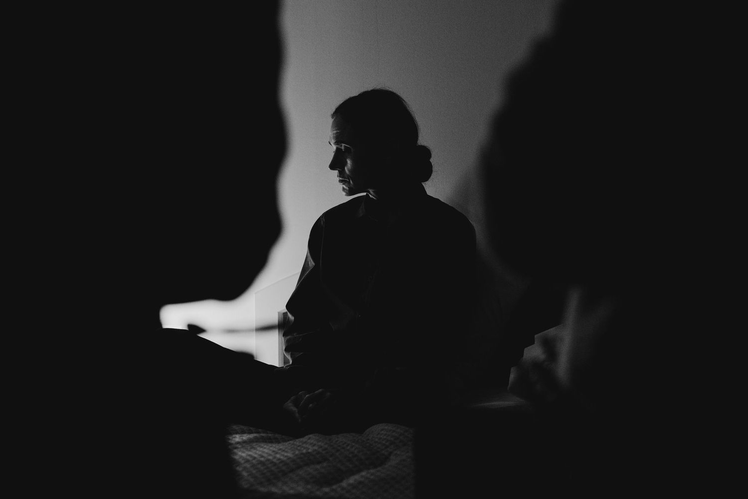 Jennifer Connelly sitting on a bed on the set of BAD BEHAVOUR in black and white