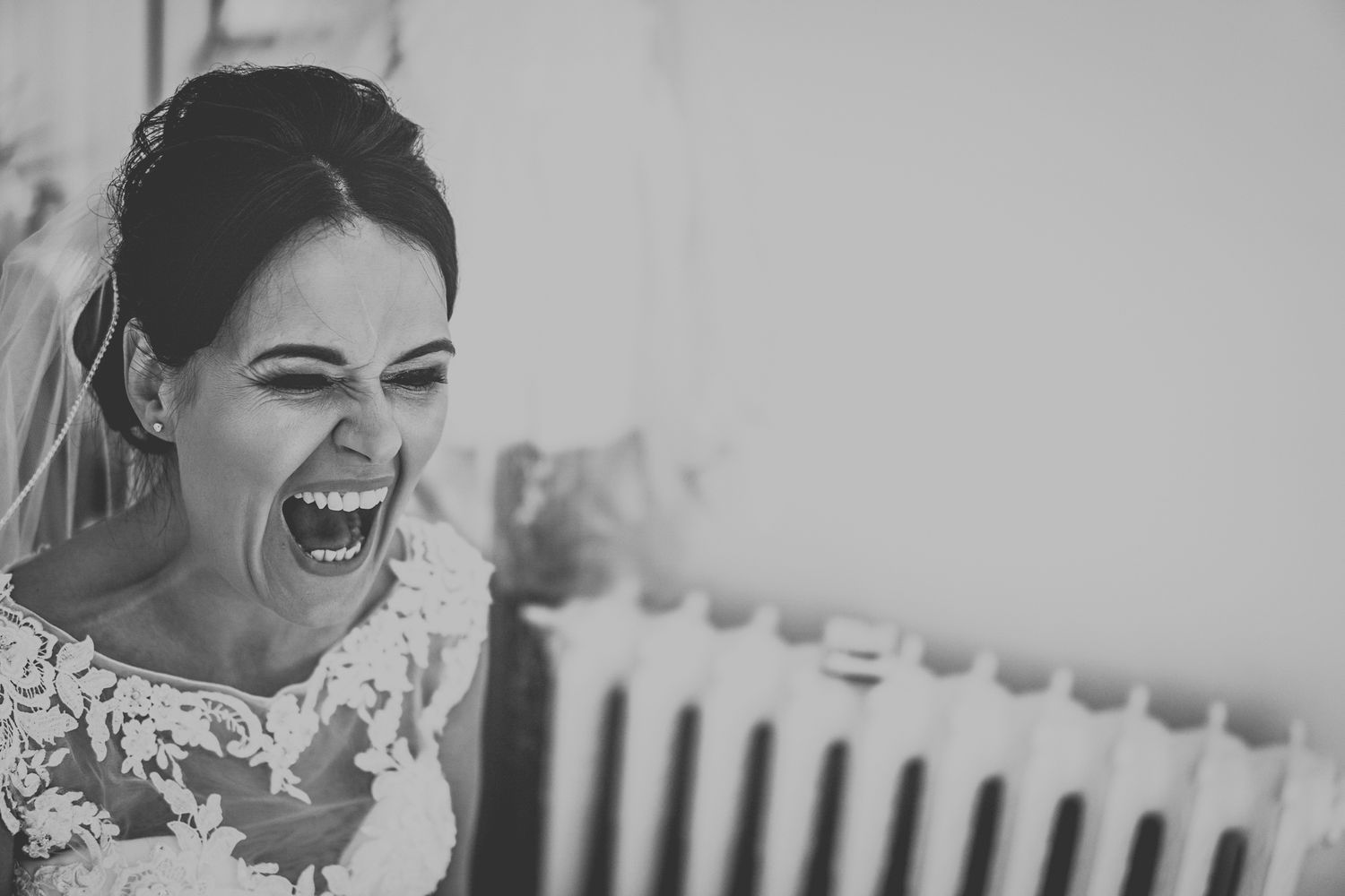 A joyful expression captured in an elegant black and white wedding portrait.